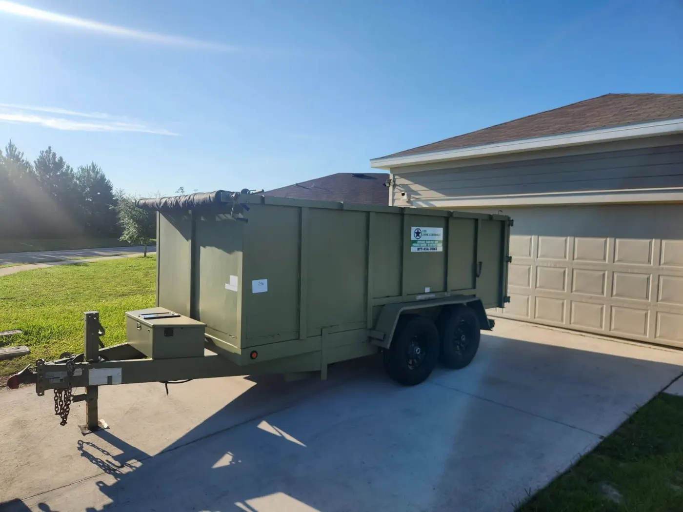 The Junk Generals dump trailer staged in a driveway before a job